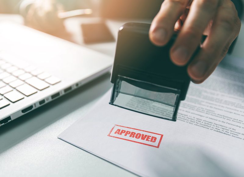 approved stamp - businessman stamping document in office