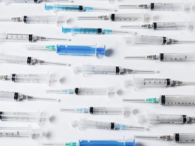 Many medical syringes as a background. Medical equipment.